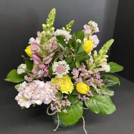 Mixed bouquet of pink and yellow flowers in a small vase