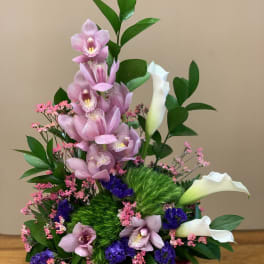 Pink orchids and white calla lilies in a magenta container