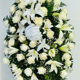 White rose and lily standing spray with a ribbon bow