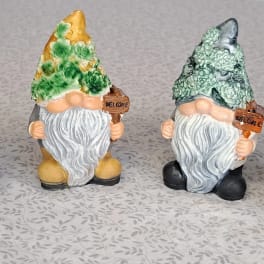 Set of four garden gnome figurines with flower-textured hats holding welcome signs