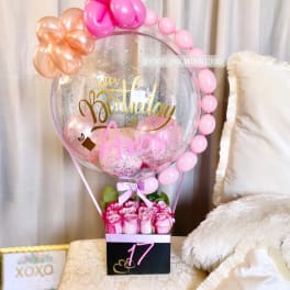 Pink rose bouquet with a birthday balloon display and a large clear balloon