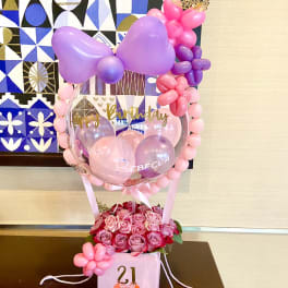 Birthday balloon display with pink roses in a gift box