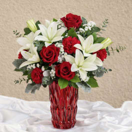 Red roses and white lilies in a red glass vase