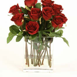 Red roses arranged in a clear glass vase