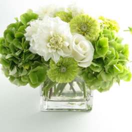 Green and white bouquet in a clear square vase