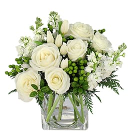 White roses and tulips in a clear glass vase