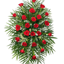 Tall standing spray of red roses arranged on lush greenery.