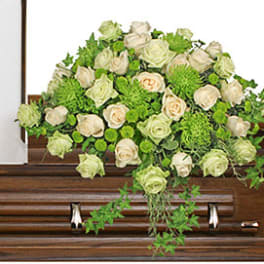 Cream roses and green flowers arranged on a casket