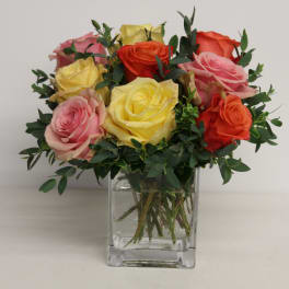Mixed roses in a clear square vase