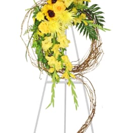 Yellow floral wreath with cascading blooms on a stand