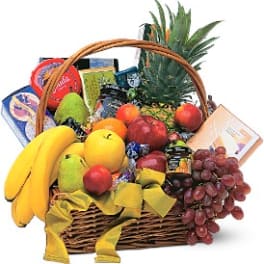 Fruit basket with bananas, grapes, apples, pineapple, and packaged snacks
