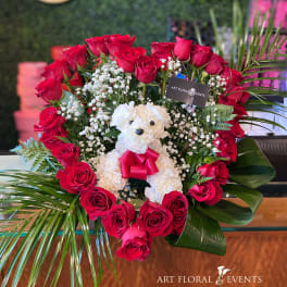 Heart-shaped rose arrangement with a white teddy bear in the center