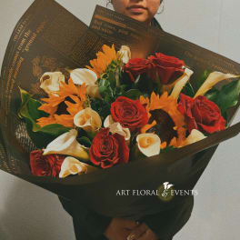 Bouquet of red roses, white calla lilies, and orange flowers wrapped in black paper