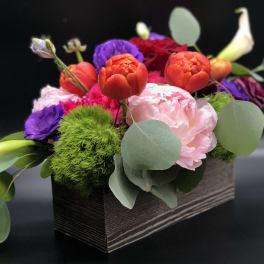 Colorful mixed flower arrangement in a rectangular box with calla lilies