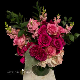 Pink rose bouquet with snapdragons and greenery in a glass vase
