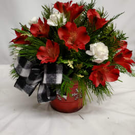Red and white flowers arranged in a red pot with a black-and-white ribbon