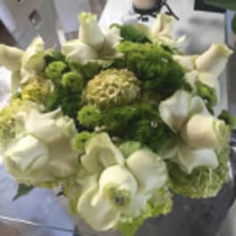 Round bouquet of cream roses and green blooms with jeweled accents in a compact arrangement