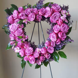 Pink rose wreath on a metal stand with small accent flowers