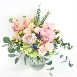 Pink and cream floral arrangement in a glass vase