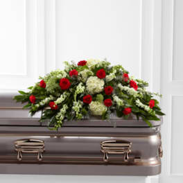 Red roses and white flowers arranged on a casket