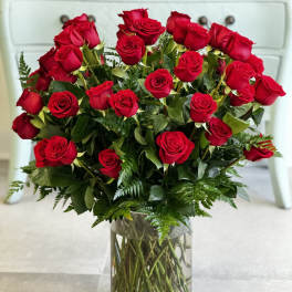 Red roses arranged in a clear glass vase