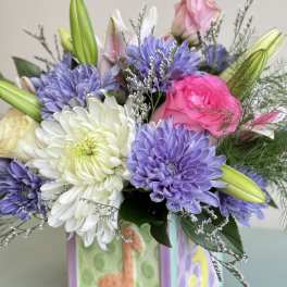 Bouquet of pink, white, and purple flowers in a decorated vase