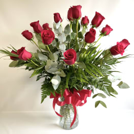 Bouquet of red roses in a glass vase with a red ribbon