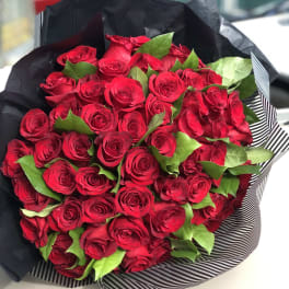 Bouquet of red roses wrapped in black paper