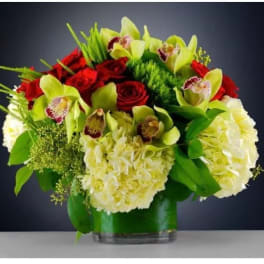 Red roses and pale green orchids in a glass vase