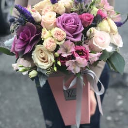 Hand-tied bouquet of pink, cream, and purple roses with alstroemeria
