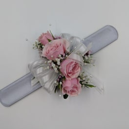 Pink rose corsage with white ribbon on a pale blue wristband