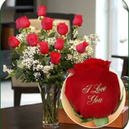 Bouquet of red roses in a glass vase with a single rose gift box