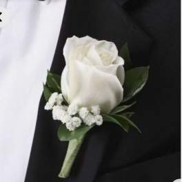 White rose boutonniere with small white filler flowers on a black suit
