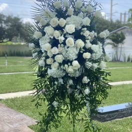 Large white floral standing spray with roses and cascading greenery