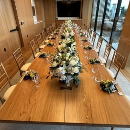 Long banquet table with white floral centerpieces and place settings