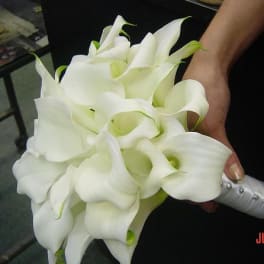 Bouquet of white calla lilies held in a hand