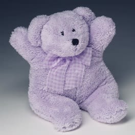 Soft lavender teddy bear with a checked bow sitting upright.