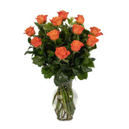 Dozen orange roses arranged in a clear glass vase with water