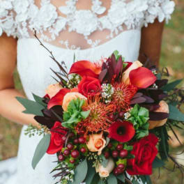 Bride holding a red and peach wedding bouquet