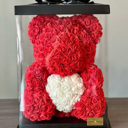 Red rose teddy bear in a clear gift box with a white heart