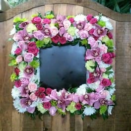 Square floral frame of pink and purple flowers around a dark center