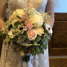 Bride holding a bouquet of white and blush flowers