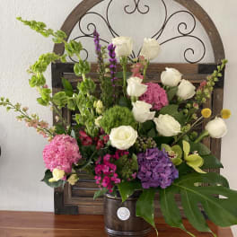 Mixed bouquet with white roses and pink and purple blooms in a metal bucket