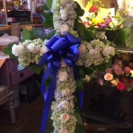 White floral cross with a blue ribbon bow