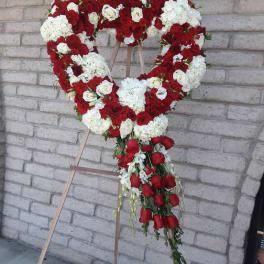 Heart-shaped floral wreath of red and white roses on an easel