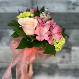 Pink rose bouquet with alstroemeria and green hydrangeas tied with a pink ribbon