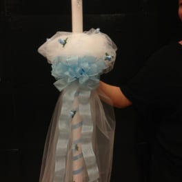 Decorated white candle with pale blue ribbon and tulle
