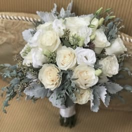 White rose bouquet with gray foliage and a wrapped handle
