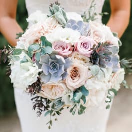 Bride holding a pastel bouquet of roses and succulents