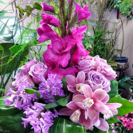 Tall pink and lavender floral arrangement in a clear vase
